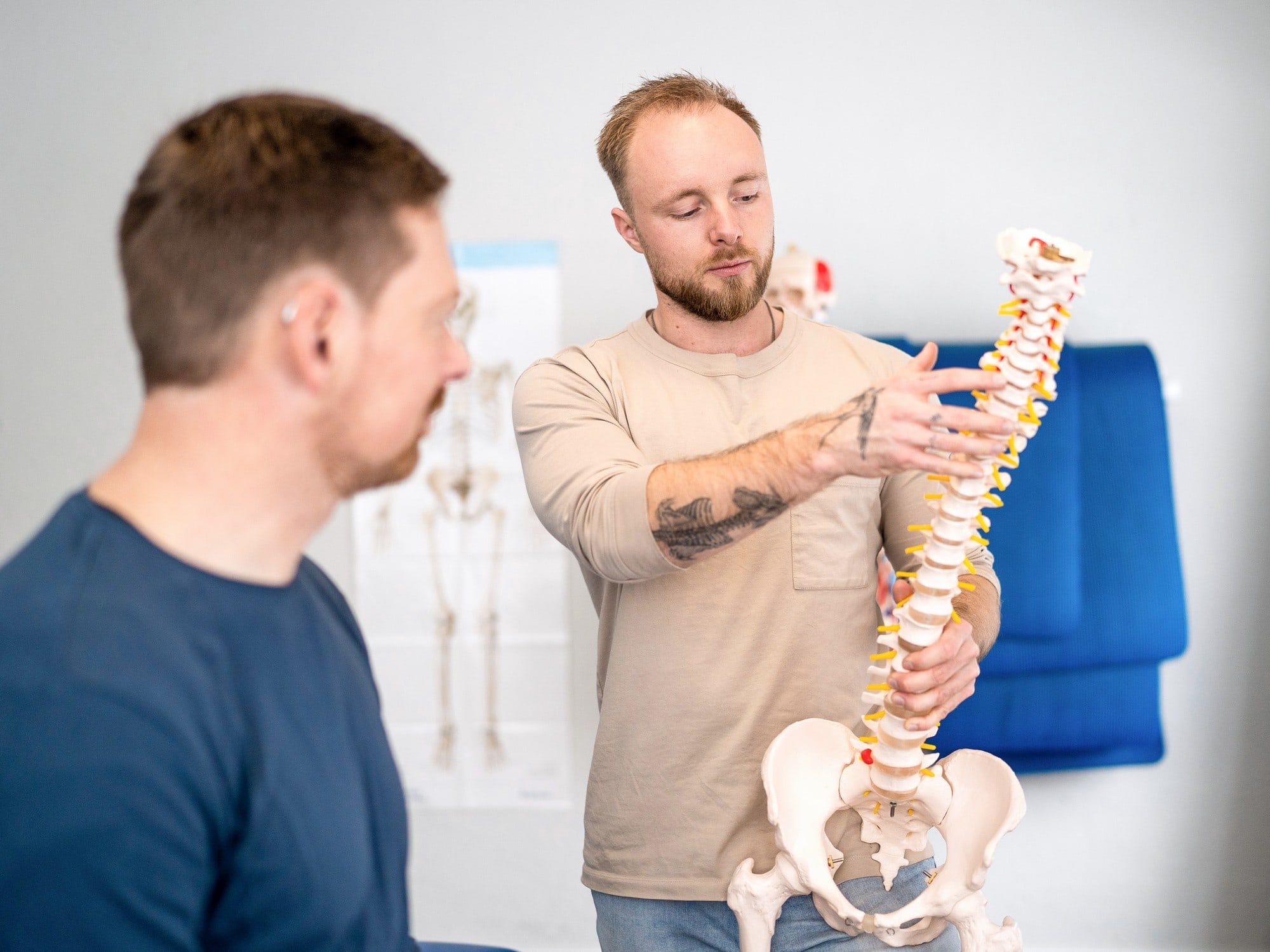 Ole erklärt einem Patienten die Zusammenhänge am Wirbelsäulenmodell
